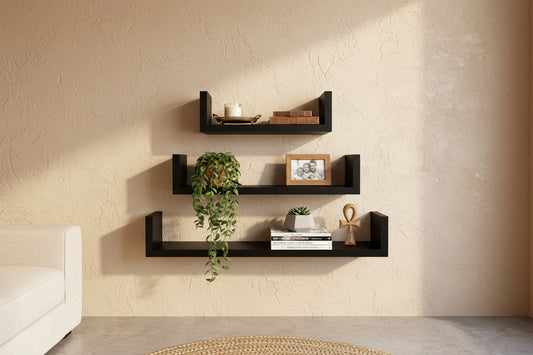 Set of black wall shelves with decorative items on a white background